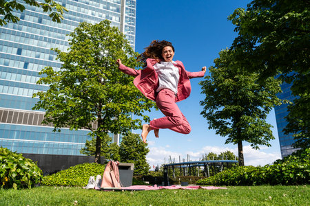 Beautiful young corporate businesswoman wearing colorful elegant suit strolling in the city - Cheerful caucasian woman going to workの写真素材
