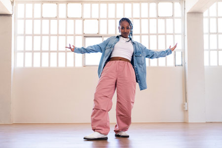 Hip-hop female dancer wearing colorful urban streetwear dancing - Stylish multiracial rap crew member portrait in the dance studioの写真素材
