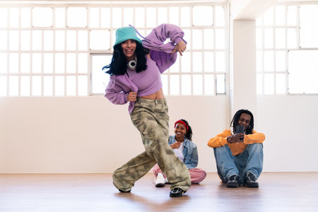 Young group of multiethnic hip-hop dancers wearing colorful urban streetwear dancing - Stylish...
