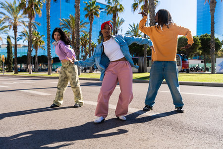 Young group of multiethnic hip-hop dancers wearing colorful urban streetwear dancing - Stylish...