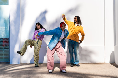 Young group of multiethnic hip-hop dancers wearing colorful urban streetwear dancing - Stylish multiracial rap crew portrait in the cityの写真素材