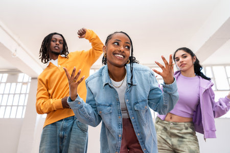 Young group of multiethnic hip-hop dancers wearing colorful urban streetwear dancing - Stylish multiracial rap crew portrait in the dance studioの写真素材