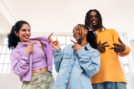 Young group of multiethnic hip-hop dancers wearing colorful urban streetwear dancing - Stylish multiracial rap crew portrait in the dance studioの写真素材