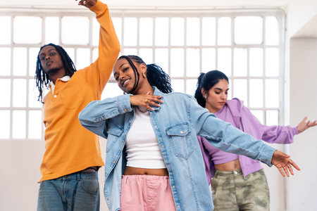 Young group of multiethnic hip-hop dancers wearing colorful urban streetwear dancing - Stylish multiracial rap crew portrait in the dance studioの写真素材