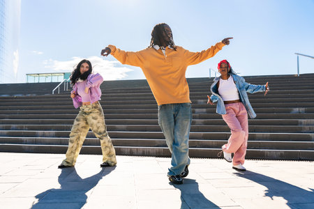 Young group of multiethnic hip-hop dancers wearing colorful urban streetwear dancing - Stylish...