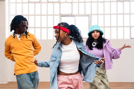 Young group of multiethnic hip-hop dancers wearing colorful urban streetwear dancing - Stylish multiracial rap crew portrait in the dance studioの写真素材