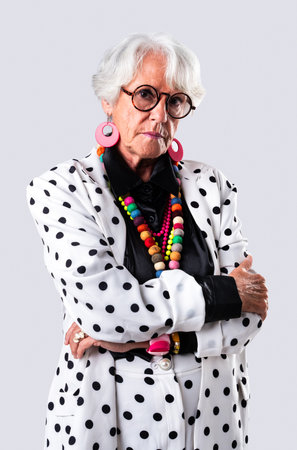 Beautiful senior woman with gray hair wearing colorful stylish clothing portrait in studio - Cheerful old grandmother with fashionable styleの写真素材