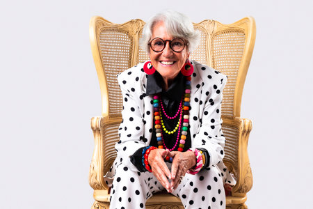 Beautiful senior woman with gray hair wearing colorful stylish clothing portrait in studio - Cheerful old grandmother with fashionable styleの写真素材