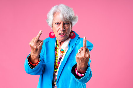 Beautiful senior woman with gray hair wearing colorful stylish clothing portrait in studio - Cheerful old grandmother with fashionable styleの写真素材