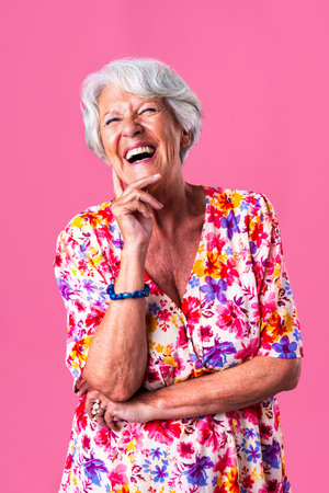 Beautiful senior woman with gray hair wearing colorful stylish clothing portrait in studio - Cheerful old grandmother with fashionable styleの写真素材