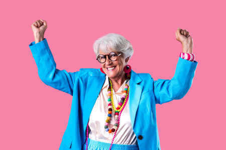 Beautiful senior woman with gray hair wearing colorful stylish clothing portrait in studio -...