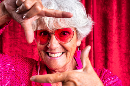 Beautiful senior woman with gray hair wearing colorful stylish clothing portrait in studio - Cheerful old grandmother with fashionable styleの写真素材