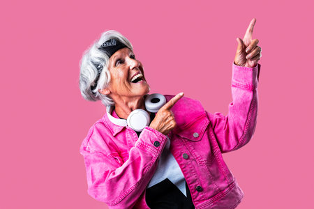 Beautiful senior woman with gray hair wearing colorful stylish clothing portrait in studio - Cheerful old grandmother with fashionable styleの写真素材