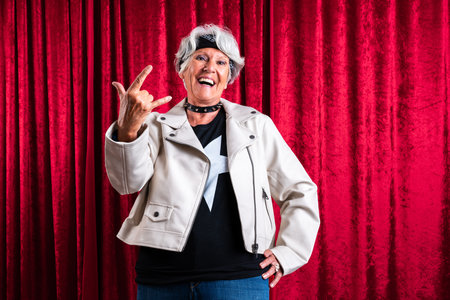 Beautiful senior woman with gray hair wearing colorful stylish clothing portrait in studio - Cheerful old grandmother with fashionable styleの写真素材