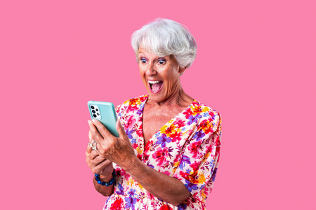 Beautiful senior woman with gray hair wearing colorful stylish clothing portrait in studio - Cheerful old grandmother with fashionable styleの写真素材