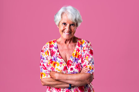 Beautiful senior woman with gray hair wearing colorful stylish clothing portrait in studio - Cheerful old grandmother with fashionable styleの写真素材