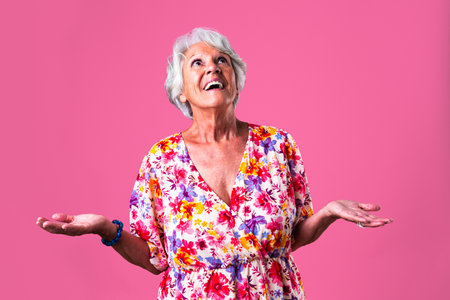 Beautiful senior woman with gray hair wearing colorful stylish clothing portrait in studio - Cheerful old grandmother with fashionable styleの写真素材