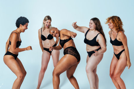 Multiethnic group of women wearing underwear with diverse kind of bodies posing in studio to celebrate diversity and self esteem - body positive, authenticity, women's power and body acceptance conceptsの写真素材