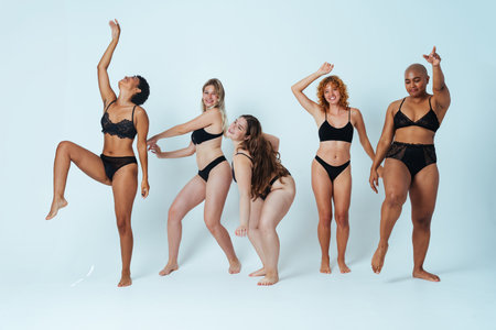 Multiethnic group of women wearing underwear with diverse kind of bodies posing in studio to celebrate diversity and self esteem - body positive, authenticity, women's power and body acceptance conceptsの写真素材