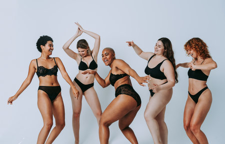 Multiethnic group of women wearing underwear with diverse kind of bodies posing in studio to celebrate diversity and self esteem - body positive, authenticity, women's power and body acceptance conceptsの写真素材