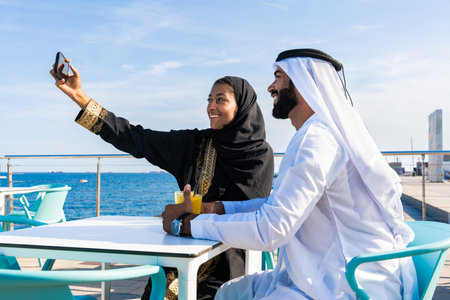 Traditional arab couple wearing emirati clothing dating outdoors - Middle-eastern married woman with...