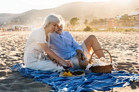 Beautiful happy senior couple dating at the seaside during summertime - Mature married couple in love bonding outdoors at the beach, concepts about elderly lifestyle, relationship and quality of lifeの写真素材