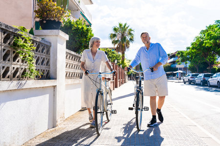 Beautiful happy senior couple dating at the seaside during summertime - Mature married couple in love bonding outdoors at the beach, concepts about elderly lifestyle, relationship and quality of lifeの写真素材