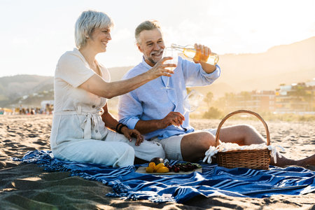 Beautiful happy senior couple dating at the seaside during summertime - Mature married couple in love bonding outdoors at the beach, concepts about elderly lifestyle, relationship and quality of lifeの写真素材