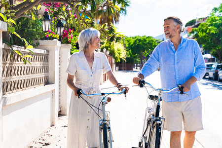 Beautiful happy senior couple dating at the seaside during summertime - Mature married couple in love bonding outdoors at the beach, concepts about elderly lifestyle, relationship and quality of lifeの写真素材