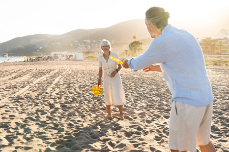 Beautiful happy senior couple dating at the seaside during summertime - Mature married couple in love bonding outdoors at the beach, concepts about elderly lifestyle, relationship and quality of lifeの写真素材