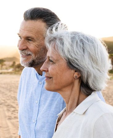 Beautiful happy senior couple at the seaside during summertime - Mature married couple in love bonding outdoors at the beach, concepts about elderly lifestyle, relationship and quality of lifeの写真素材