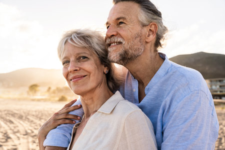 Beautiful happy senior couple dating at the seaside during summertime - Mature married couple in love bonding outdoors at the beach, concepts about elderly lifestyle, relationship and quality of lifeの写真素材