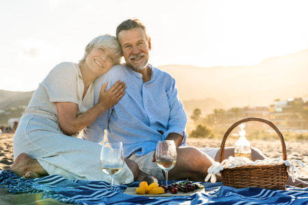 Beautiful happy senior couple dating at the seaside during summertime - Mature married couple in love bonding outdoors at the beach, concepts about elderly lifestyle, relationship and quality of lifeの写真素材