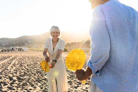 Beautiful happy senior couple dating at the seaside during summertime - Mature married couple in love bonding outdoors at the beach, concepts about elderly lifestyle, relationship and quality of lifeの写真素材