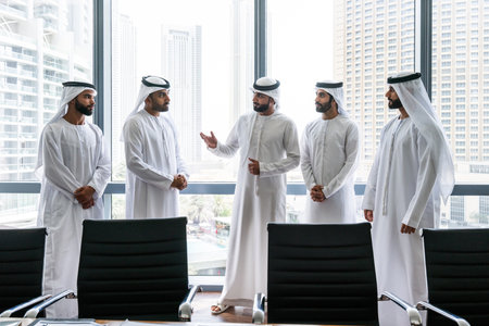 Arab businessmen wearing emirati kandura meeting in office for business deal - Corporate business group of middle-eastern people working in an international company in middle eastの写真素材
