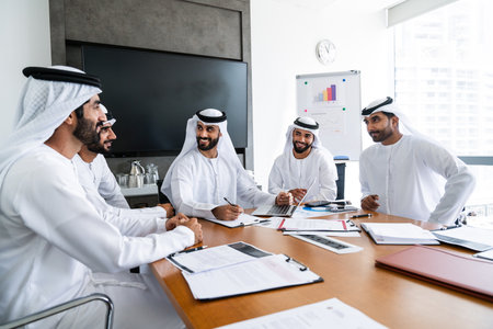 Arab businessmen wearing emirati kandura meeting in office for business deal - Corporate business group of middle-eastern people working in an international company in middle eastの写真素材
