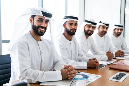 Arab businessmen wearing emirati kandura meeting in office for business deal - Corporate business group of middle-eastern people working in an international company in middle eastの写真素材