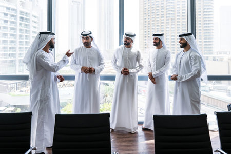 Arab businessmen wearing emirati kandura meeting in office for business deal - Corporate business group of middle-eastern people working in an international company in middle eastの写真素材