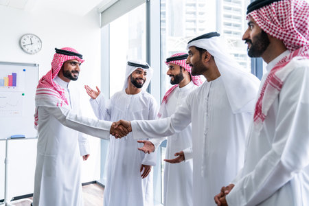 Arab businessmen wearing emirati and saudi kandura meeting in office for business deal - Corporate business group of middle-eastern people working in an international company in middle eastの写真素材