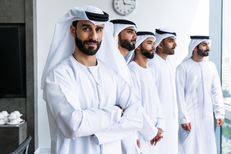Arab businessmen wearing emirati kandura meeting in office for business deal - Corporate business group of middle-eastern people working in an international company in middle eastの写真素材