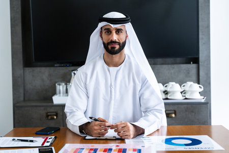 Arab businessman wearing emirati kandura meeting in office for business deal - Corporate business middle-eastern male adult working in an international company in middle eastの写真素材