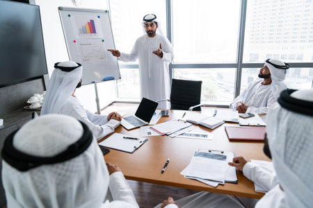 Arab businessmen wearing emirati kandura meeting in office for business deal - Corporate business group of middle-eastern people working in an international company in middle eastの写真素材