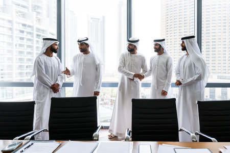 Arab businessmen wearing emirati kandura meeting in office for business deal - Corporate business group of middle-eastern people working in an international company in middle eastの写真素材