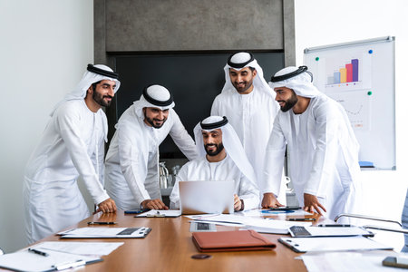 Arab businessmen wearing emirati kandura meeting in office for business deal - Corporate business group of middle-eastern people working in an international company in middle eastの写真素材