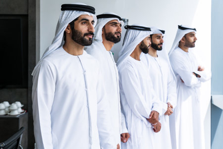 Arab businessmen wearing emirati kandura meeting in office for business deal - Corporate business group of middle-eastern people working in an international company in middle eastの写真素材