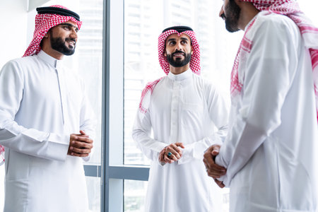 Arab businessmen wearing saudi kandura meeting in office for business deal - Corporate business group of middle-eastern people working in an international company in middle eastの写真素材