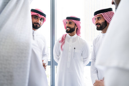 Arab businessmen wearing emirati and saudi kandura meeting in office for business deal - Corporate business group of middle-eastern people working in an international company in middle eastの写真素材