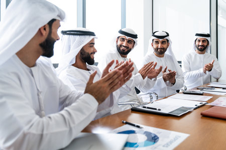 Arab businessmen wearing emirati kandura meeting in office for business deal - Corporate business group of middle-eastern people working in an international company in middle eastの写真素材