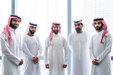 Arab businessmen wearing emirati and saudi kandura meeting in office for business deal - Corporate business group of middle-eastern people working in an international company in middle eastの写真素材