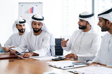 Arab businessmen wearing emirati kandura meeting in office for business deal - Corporate business group of middle-eastern people working in an international company in middle eastの写真素材